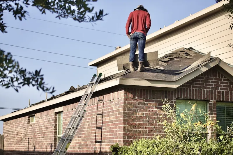 Professional roofer working on a residential roof in Burschville